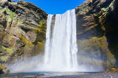 Low angle view of waterfall against sky