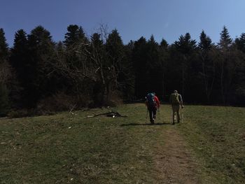 People walking on grass against sky