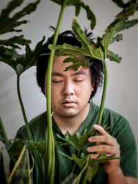 Portrait of young man with plant