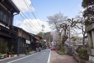 Cars on road amidst buildings against sky