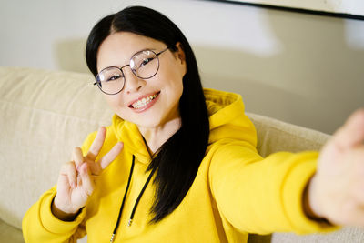 Portrait of young woman sitting at home