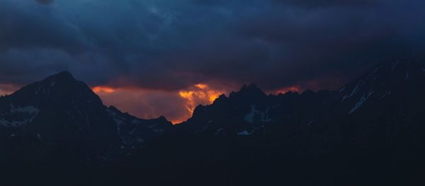 Scenic view of silhouette mountains against sky during sunset