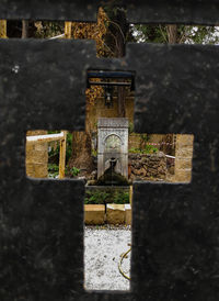 Close-up of metal structure in cemetery against building