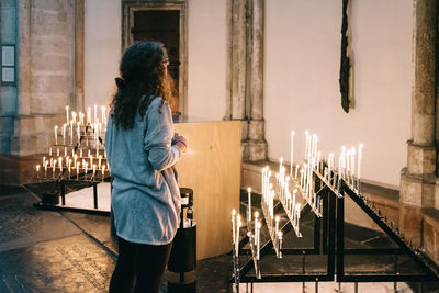 Woman standing against illuminated wall