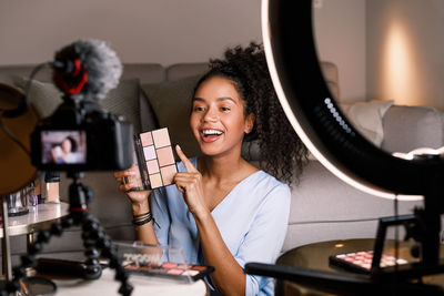 Portrait of young woman holding camera