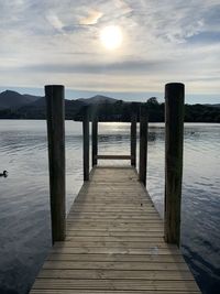 Wooden jetty on pier over sea against sky