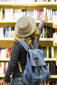 Rear view of woman standing in library