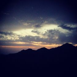 Scenic view of mountains against cloudy sky