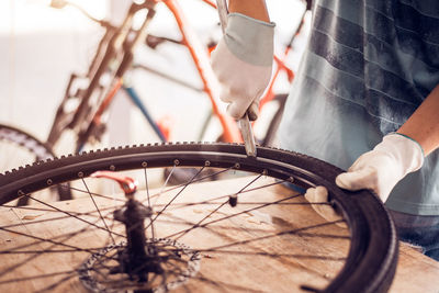 Midsection of man repairing bicycle tire