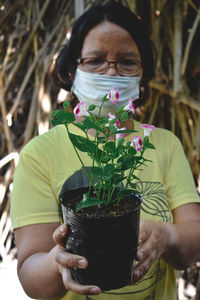 Midsection of man holding potted plant