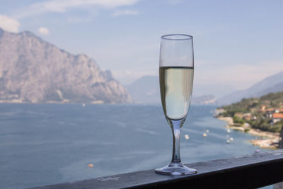 Glass of champagne in mountains against sky