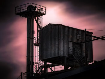 Low angle view of silhouette crane against sky at sunset