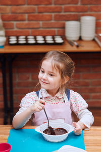 Cute girl mixing batter in bowl