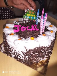 Cropped image of hand holding chocolate cake