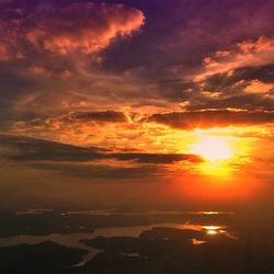 Scenic view of sea against cloudy sky during sunset