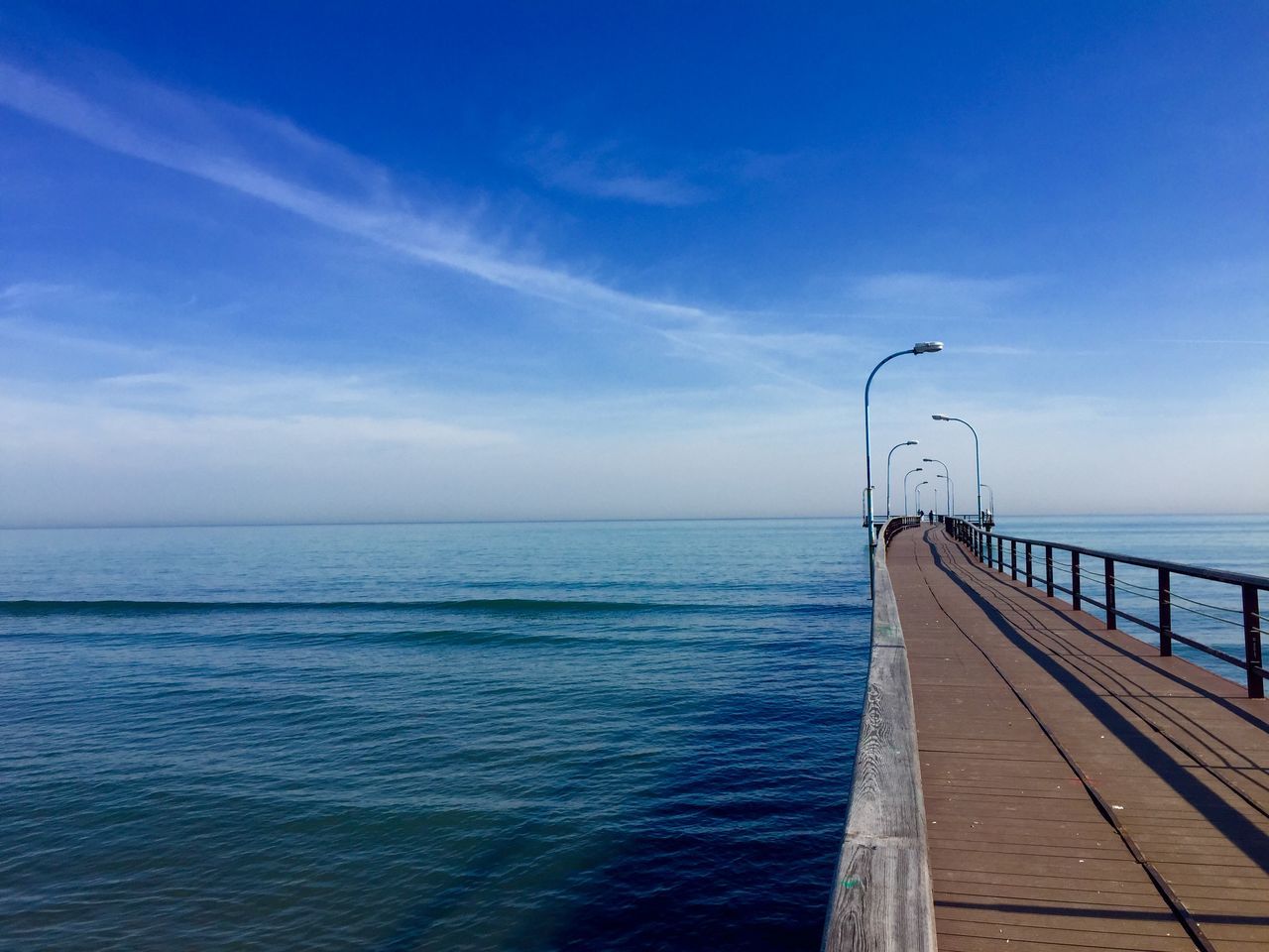 sea, horizon over water, water, sky, pier, railing, scenics, blue, tranquil scene, tranquility, nature, beauty in nature, the way forward, cloud, cloud - sky, built structure, rippled, idyllic, diminishing perspective, outdoors