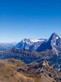 Scenic view of snowcapped mountains against clear blue sky