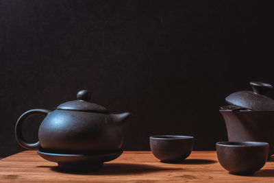 Close-up of tea cup on table against black background