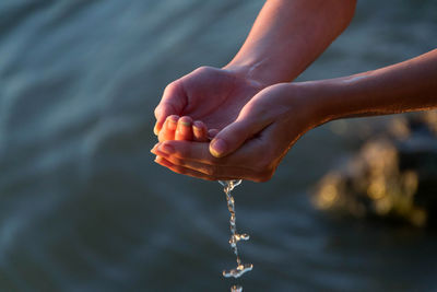 Close-up of hand falling water