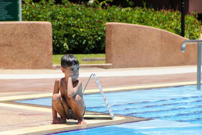 Portrait of boy by swimming pool