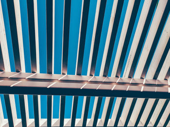 Low angle view of railing against blue sky