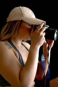 Woman photographing against black background