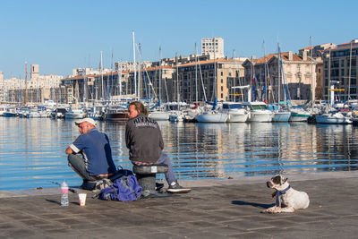 View of boats in harbor against clear sky