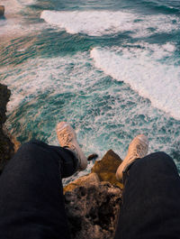 Low section of man on rock by sea