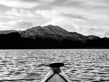 Rear view of man on lake against mountain range