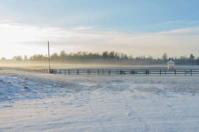 Snow covered field against sky