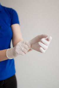 Close-up of woman holding hands over white background