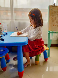 Girl sitting on table at home