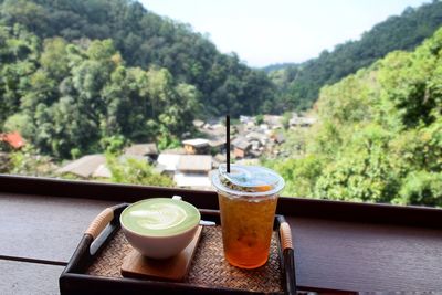 Cup of matcha latte on wooden floor in coffee shop.