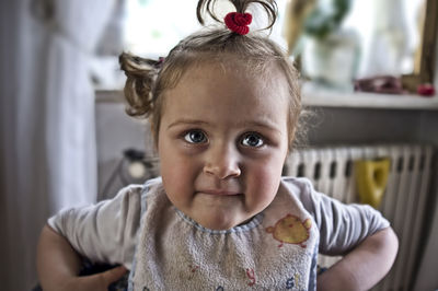 Close-up portrait of a cute liitle baby with funny pony tails and bib