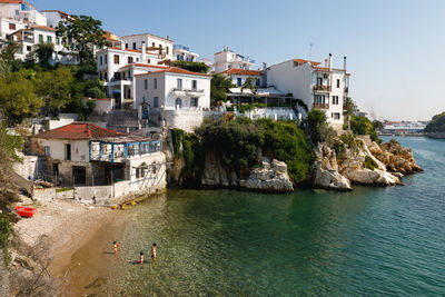 Buildings by sea against clear sky