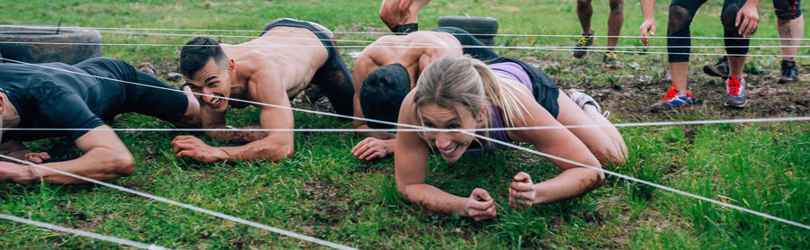 Friends crawling under strings on land