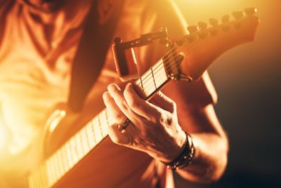 Midsection of man playing guitar