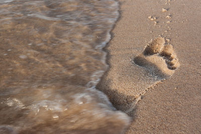 High angle view of footprints on sand at beach