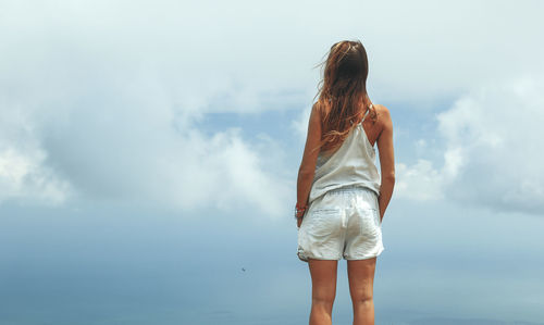 Rear view of woman standing against sky