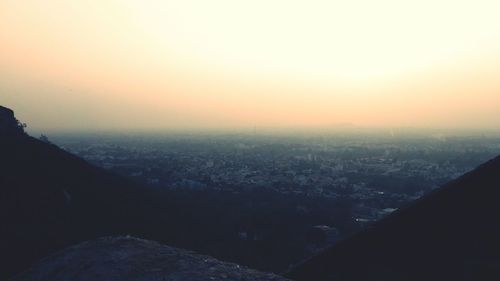 Aerial view of cityscape against sky at sunset