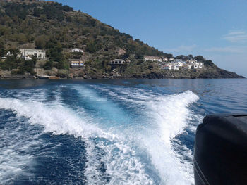 Scenic view of sea by buildings against sky