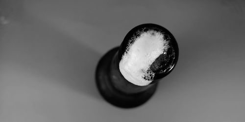 Directly above shot of cigarette on table against white background