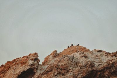 Low angle view of rocks on mountain against sky