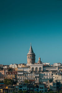Buildings in city against blue sky