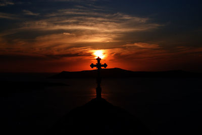 Silhouette church by the sea against sky during sunset from santorini