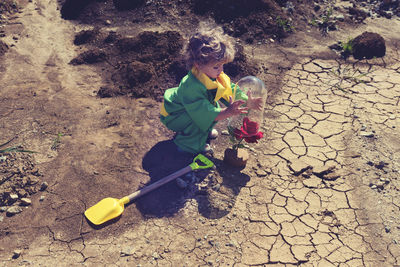 Side view of boy with flower on land