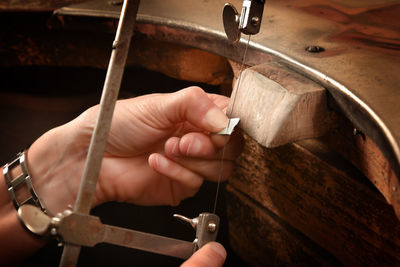 Cropped image of person holding hand saw