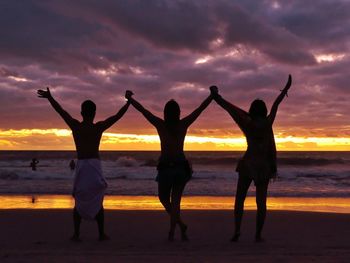 Silhouette people at beach during sunset