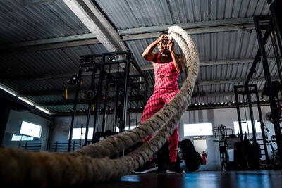 Woman doing training with naval rope. abdominal strengthening and muscular endurance.