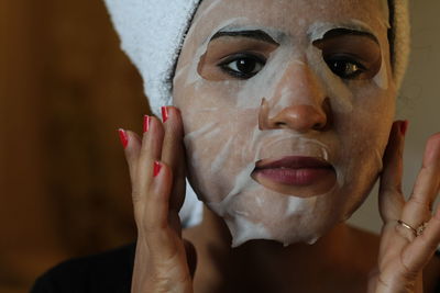 Portrait of woman using facial mask at home